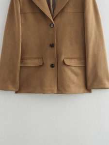 Detail of caramel brown suede blazer featuring a three-button closure and flap pockets