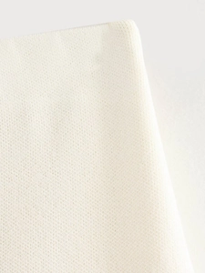 Close-up of cream knit fabric showing fine texture and breathable needlework detail