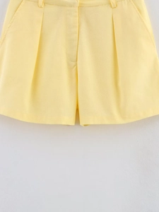 Nahaufnahme hellgelbe High-Waist-Shorts mit Falten und sichtbarer Leinenstruktur