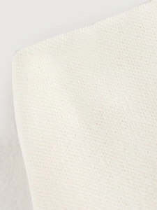 Macro shot of ivory knit fabric texture showing premium soft knitted patterns