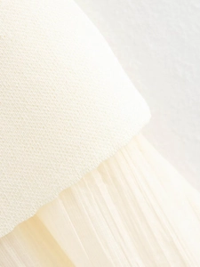 Detail of knit fabric stitched with pleated chiffon on a cream white summer set