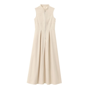 Detail of elegant beige sleeveless dress showing metal zipper and crisp pleated skirt