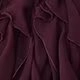 Detailopname van een wijnrode blouse met gelaagde ruches en geplooide stof