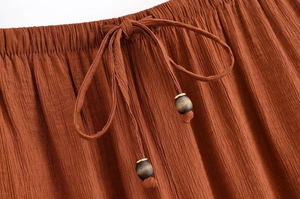 Detailansicht der elastischen Taille mit Kordelzug und Holzperlen auf Crinkle-Stoff