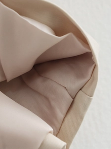 Detailed close-up showing beige twill lining texture and precise stitching on the coat