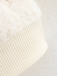 Détail du tissu sherpa crème avec bord-côte en maille sur une veste de type aviateur