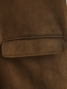 Detail view of brown suede blazer featuring flap pocket and premium stitching texture