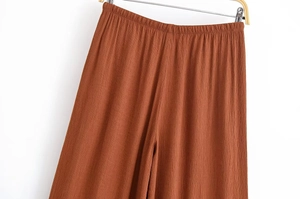 Detail der hoch taillierten weiten Hose in Ziegelrot mit elastischem Bund