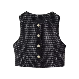 Dettaglio della trama del gilet in tweed con bottoni decorativi in metallo dorato