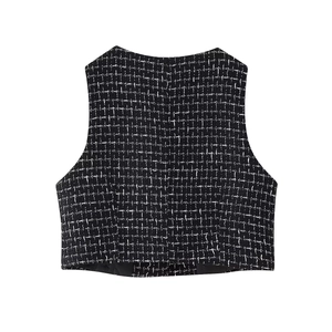 Dettaglio del gilet in tweed bianco e nero con scollo rotondo e tessuto a trama