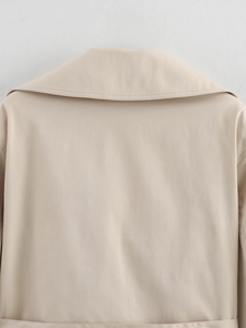 Close-up of the light beige trench coat collar showing premium twill fabric and stitching