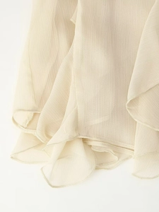 Detailopname van gelaagde ruches en getextureerde crème chiffon voor zomerblouse