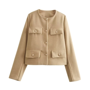 Dettaglio ravvicinato della giacca in tweed beige con bottoni dorati decorativi