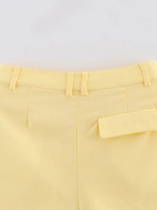 Detailansicht der gelben Shorts mit Gürtelschlaufen, Gesäßtaschenklappe und Stoffstruktur