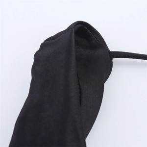 Vue macro des coutures fines et de la bretelle fine sur une robe en satin noir