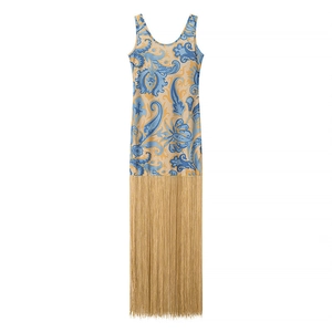 Dettaglio del vestito con stampa paisley e lunghe frange dorate sull'orlo