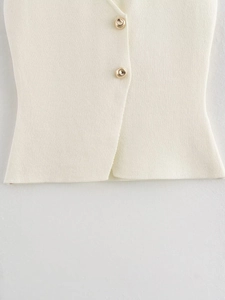Detail view of cream knitted vest featuring high-quality polished golden buttons