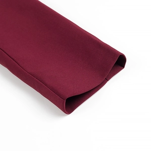 Close-up of deep red suit blazer cuff showing premium twill fabric texture and tailoring