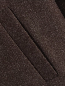 Dettaglio cappotto in lana marrone scuro con tasca diagonale e trama del tessuto