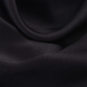 Détail du tissu en satin noir luxueux montrant une texture lisse et un drapé élégant