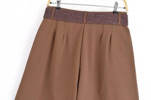 Détail du short marron foncé à taille haute avec ceinture tressée et plis élégants