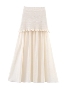 Détail du haut en tricot blanc et jupe tissée plissée avec bords ondulés délicats
