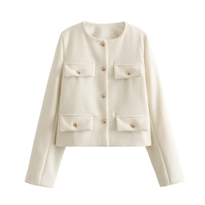 Dettaglio del blazer in tweed che mostra il tessuto crema e i bottoni dorati
