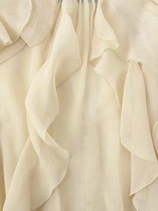 Detail van ivoren chiffon met gelaagde ruches en verticale geplooide textuur