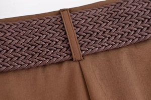 Vue détaillée macro d'une ceinture tressée marron et de la taille en tissu texturé