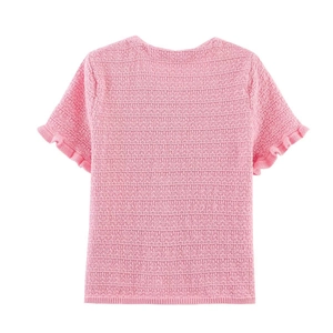 Détail macro du haut en maille rose avec fil bouclé texturé et poignets à volants