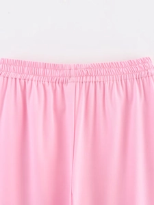Detail of pink pants featuring elastic waistband with neat pleats and fine fabric texture