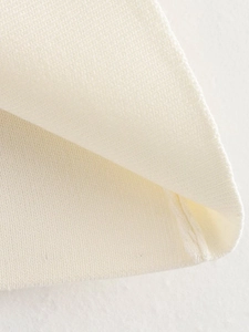 Detailed macro view showing the fine knit texture and neat stitching of the cream top