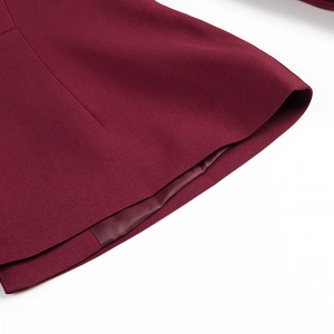 Detailed macro view of dark red blazer sleeve edge with twill texture and neat lining