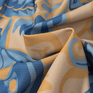 Dettaglio del tessuto intrecciato blu e beige con trama a nido d'ape e stampa astratta