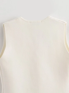 Détail du col rond et de la maille fine du débardeur en tricot de couleur blanc cassé