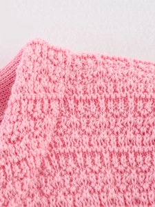 Vue détaillée du tissu en maille rose avec motif de tissage 3D sophistiqué et doux