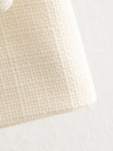 Primo piano del tessuto tweed color crema con trama intrecciata classica di alta qualità