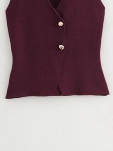 Gros plan d'un gilet en tricot bordeaux avec col en V et boutons dorés décoratifs
