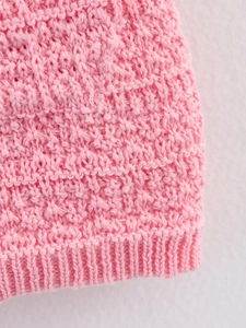 Détail macro de maille rose avec des côtes verticales et une texture douce et moelleuse