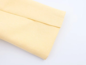 Detailed close-up showing light yellow cotton fabric texture and clean weave pattern