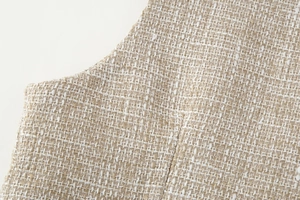 Dettaglio macro del tessuto in tweed testurizzato con trama intrecciata beige e marrone
