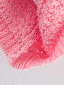 Gros plan sur un tricot rose montrant la texture détaillée et le tissage doux du vêtement