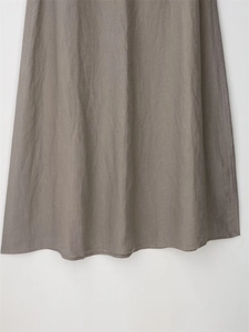 Détail de l'ourlet d'une jupe longue taupe en coton et lin montrant la texture du tissu