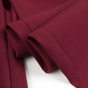 Macro shot of wine red twill suit fabric showing precise hem stitching and dense texture