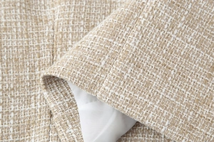 Vista macro della trama del tessuto tweed beige e bianco con fili di seta dorati