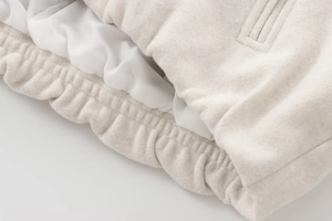 Detail of soft cream bomber jacket showing textured faux shearling and satin lining