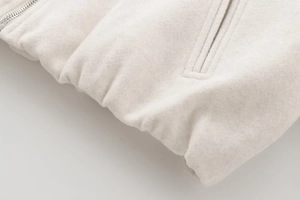 Detailed view of silver zipper and pocket on white soft wool blend bomber jacket