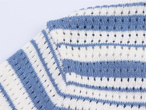 Détail macro du tricot à rayures bleues et blanches avec motifs ajourés délicats