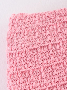 Vue macro de la texture tricotée rose et détails de couture pour ensemble d'été