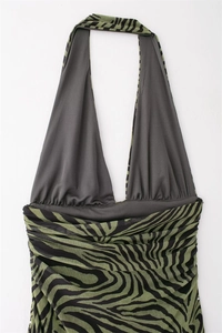 Detail of green zebra print halter dress showing deep V-neck and pleated waist fabric